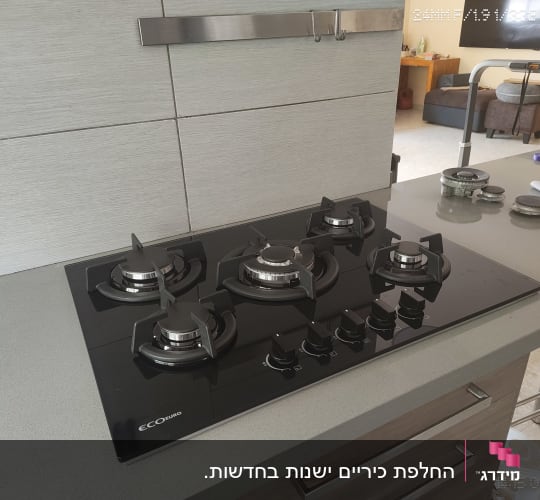 כיריים גז זכוכית שחורה מותקנות על שיש במטבח